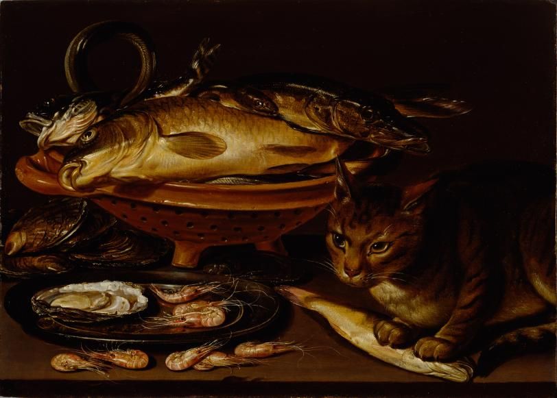 Fish and oyster shells arranged on a table beside a cat holding a fish.